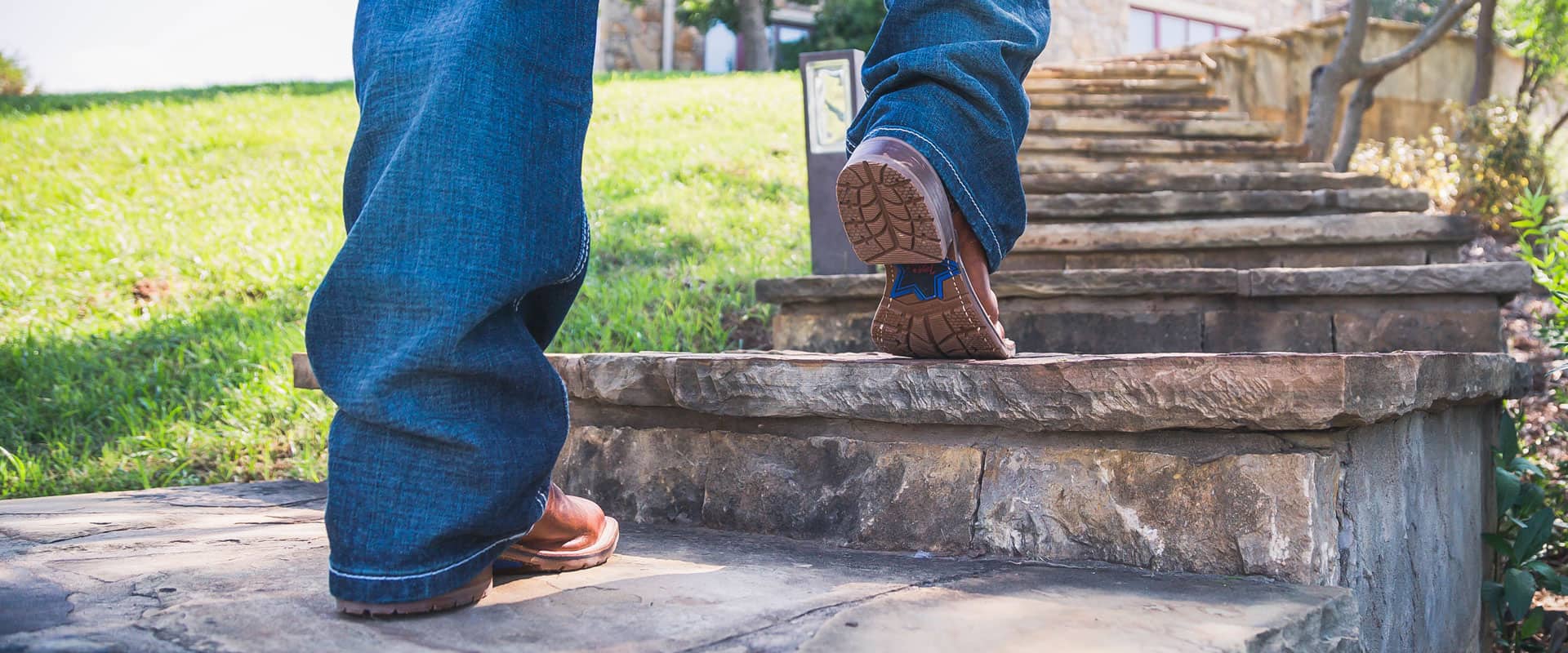 Man walks up stairs in pair of Tony Lama boots.